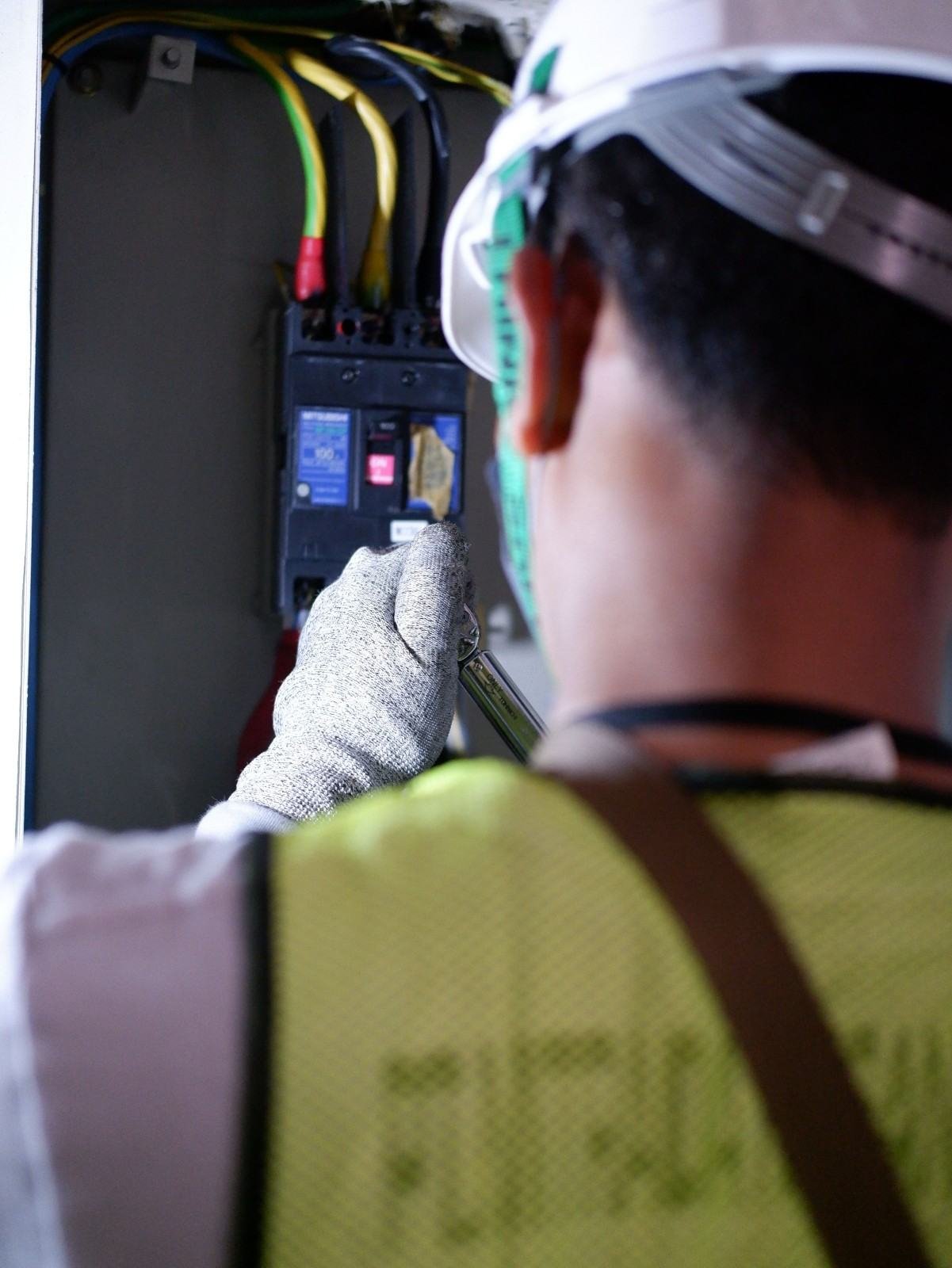 Electrician servicing an electrical transfer switch panel