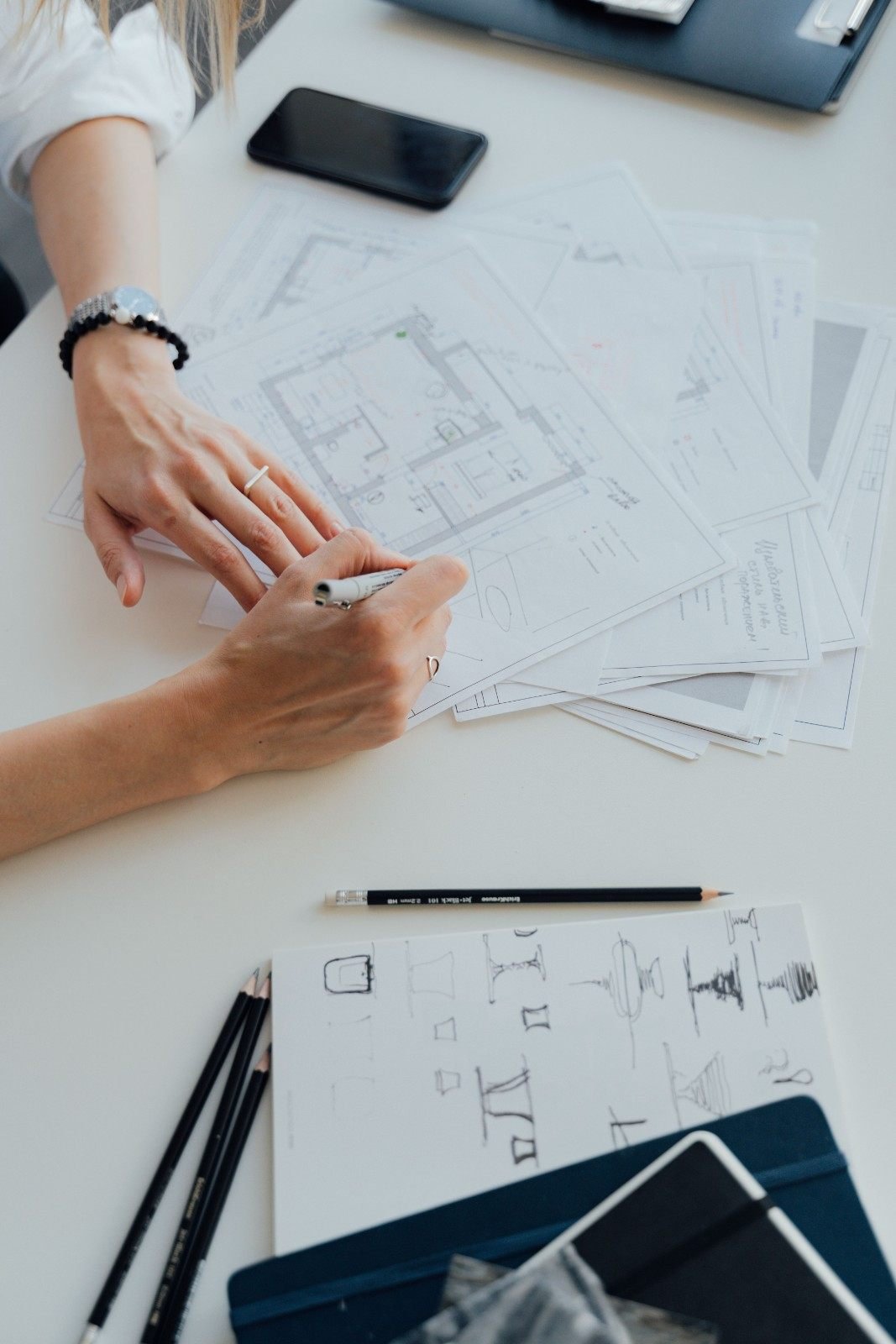 Designer reviewing architectural floor plans for custom lighting design in West Palm Beach, FL